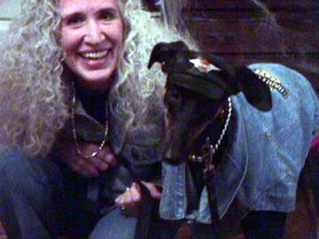 Maya, black Greyhound, and Charlotte dressed in Harley jackets and silver necklaces.